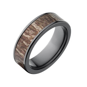 May include: A black ceramic ring with a brown wood inlay. The ring has a polished finish and a beveled edge.