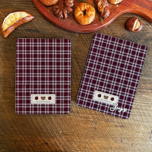 May include: Two red and white plaid fabric covers with a brown bear and red apple design. The text on the covers reads "Cute Bear and Red Apple".