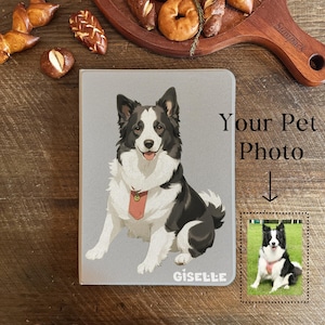 Könnte beinhalten: Ein graues Haustier-Foto-Notizbuch mit einer schwarz-weißen Hundeillustration und dem Namen "Giselle". Das Notizbuch trägt den Text "Your Pet Photo" und ein kleineres Foto des Hundes. Der Hintergrund ist eine Holzoberfläche mit Backwaren.