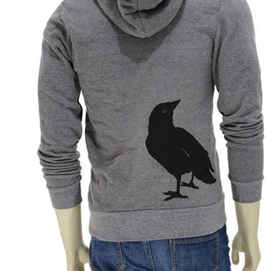 May include: A gray hooded sweatshirt with a black silhouette of a bird on the back.