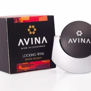 Può includere: Un tappo per bottiglia di vino nero e argento con il testo "AVINA WINE ACCESSORIES" e "LOCKING WINE Bottle Stopper" sulla confezione. Il tappo ha una parte superiore rotonda nera con il logo AVINA.