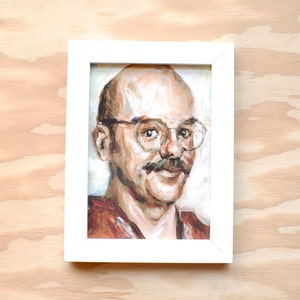 May include: A framed painting of a man with a mustache and glasses. The man is wearing a brown shirt and has a light complexion. The painting is done in a realistic style.