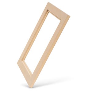 May include: A rectangular, light-colored wooden picture frame, angled diagonally against a white background. The frame is empty, showcasing the open space within. The wood has a natural, unfinished appearance.