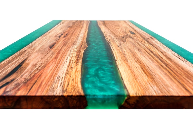 May include: Close-up of a wooden table top with a green epoxy resin river running down the center.