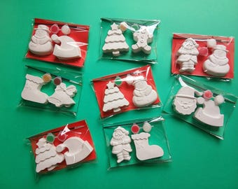 以下が含まれることがあります： クリスマスをテーマにした、自分でペイントできるクラフトキットのコレクション。 各キットには、雪だるま、サンタ、クリスマスツリーなどの白い石膏フィギュア、塗料、ブラシが含まれており、すべて赤い裏地付きの透明なビニール袋にパッケージされています。