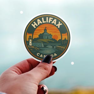Può includere: Un adesivo rotondo con un design di Halifax, Canada. L'adesivo ha una combinazione di colori verde e arancione con il testo "HALIFAX CANADA". Il design include un faro, un edificio, un ponte e un tramonto.