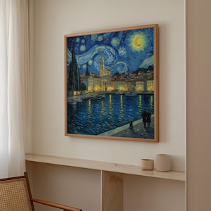 May include: A framed print depicting a starry night over a coastal town. The artwork shows a blue sky with swirling clouds, a crescent moon, and a town with illuminated buildings reflected in the water.