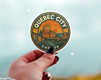May include: A round sticker featuring a vintage illustration of Quebec City, Canada. The design includes the city's skyline, a river, and a sunset. The sticker has a dark green border with the words "QUEBEC CITY" and "CANADA".