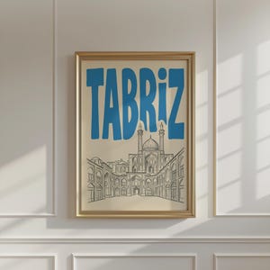 May include: A framed wall art print featuring the word TABRIZ in large, bold blue letters above a detailed black line drawing of a traditional architectural complex with a central dome and arched entryways on a light cream background.