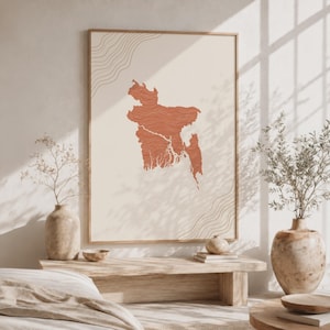Può includere: Una stampa artistica rettangolare da parete che presenta una mappa del Bangladesh color terracotta centrata su uno sfondo color crema. La mappa è riempita con sottili linee orizzontali ondulate e gli angoli mostrano delicati motivi a linee curve.