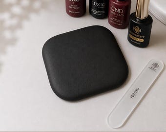 May include: A collection of nail care products, including four bottles of gel polish in various colors, a black square pad, and a nail file. The bottles are labeled with brand names and product details. The nail file has the text "100/180".