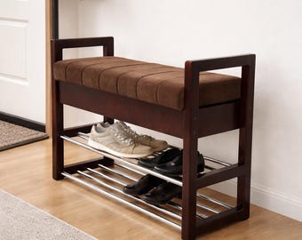 May include: A dark brown wooden shoe bench featuring a rectangular, tufted brown fabric seat cushion. The base includes two horizontal tiers of silver-toned metal rods for shoe storage, supported by a sturdy frame with square side armrests.