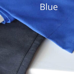 May include: Close-up of two pieces of fabric. One is a vibrant blue, with the word "Blue" in white text. The other is a dark navy blue. The fabrics appear to be smooth and possibly part of a garment.