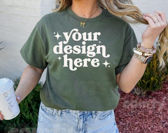 May include: A woman wearing a green t-shirt with the text "your design here" in white. The shirt has a relaxed fit and short sleeves.