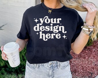 May include: A black t-shirt with the text "your design here" in white retro-style lettering. The shirt is being worn by a person with long blonde hair.