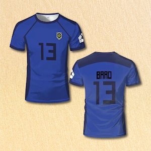 May include: Blue soccer jersey with the number 13 in black on the front and back. The front of the jersey also has the number 13 and the name "BARO" on the back. The jersey has a small emblem on the chest.