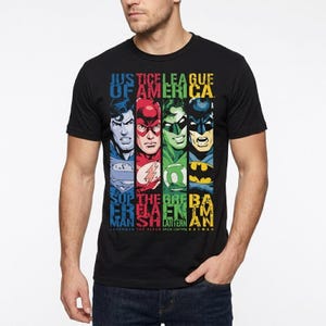 Może przedstawiać: Czarny t-shirt z krótkim rękawem z nadrukiem graficznym przedstawiającym czterech superbohaterów DC: Supermana, Flasha, Zieloną Latarnię i Batmana. Na górze znajduje się napis "JUSTICE LEAGUE OF AMERICA", a pod każdym bohaterem jego imię.