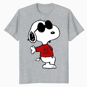 May include: A heather gray short-sleeve t-shirt featuring a graphic of the cartoon character Snoopy wearing black sunglasses and a red sweater with the text JOE COOL printed in black. The character is depicted in a standing pose.