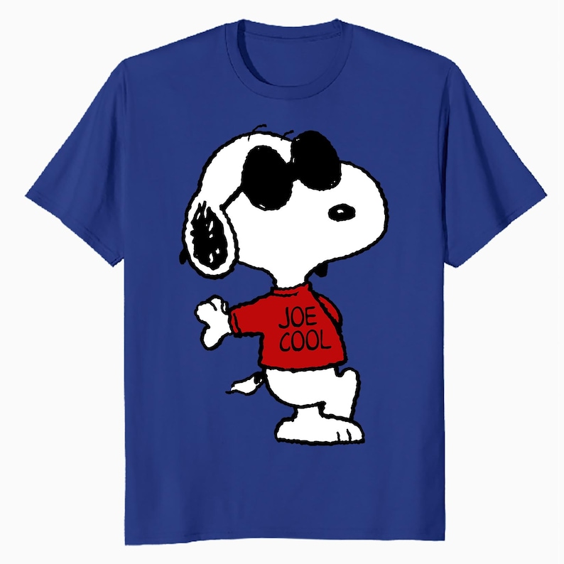 May include: A royal blue short-sleeved t-shirt featuring a graphic of the cartoon character Snoopy wearing black sunglasses and a red shirt with the text JOE COOL printed in black. The character is depicted in a standing pose with one arm raised.