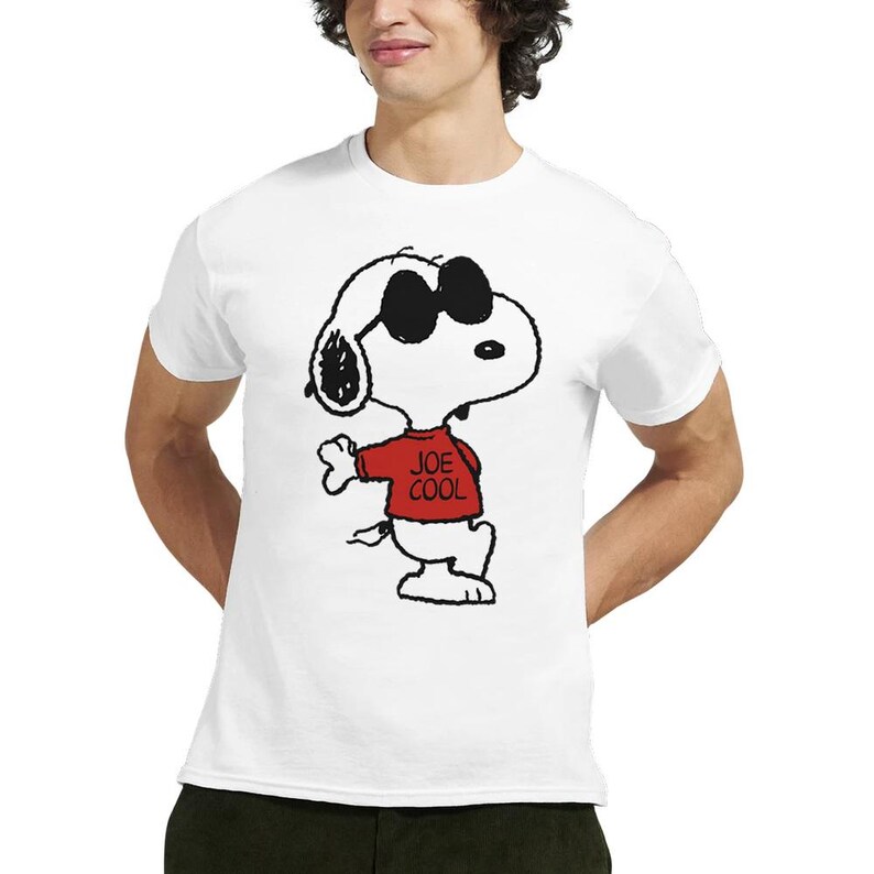 May include: A white short-sleeved t-shirt featuring a black and white graphic of the cartoon character Snoopy wearing black sunglasses and a red shirt with the text JOE COOL printed in black on the front of the shirt.