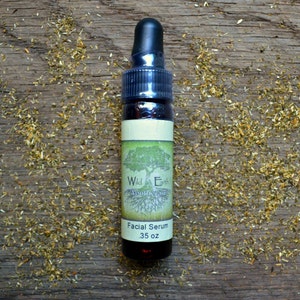 May include: A small brown glass bottle with a dropper top. The bottle is labeled "Wild Earth Apothecary" and "Facial Serum .35 oz".