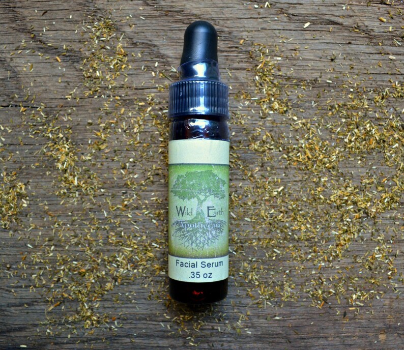 May include: A small brown glass bottle with a dropper top. The bottle is labeled "Wild Earth Apothecary" and "Facial Serum .35 oz".