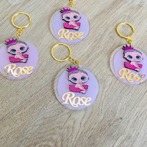 May include: Four pink and purple keyrings with a baby doll design. Each keyring has a gold key ring and the name "Rose" written in gold letters.