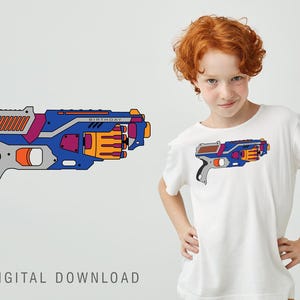 May include: A white t-shirt with a blue and orange toy gun graphic. The gun has the word "Birthday" printed on it.