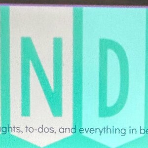 May include: A rectangular sign featuring the word MONDAY in large, light green capital letters, each set against a vertical banner shape in alternating shades of peach, white, and teal. The text thoughts, to-dos, and everything in between is printed below.