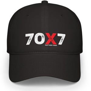 Puede incluir: Gorra de béisbol negra con el texto "70X7" en blanco y rojo, con "Matthew 18:22" debajo. La gorra tiene una visera curva y un botón en la parte superior.