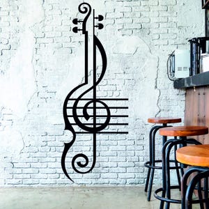 Pu&ograve; includere: Adesivo da parete in bianco e nero di una chiave di violino con note musicali e linee. L'adesivo &egrave; su un muro di mattoni bianchi.