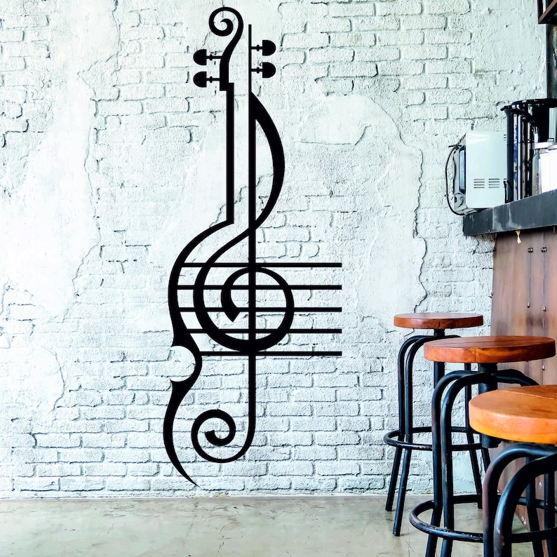 Pu&ograve; includere: Adesivo da parete in bianco e nero di una chiave di violino con note musicali e linee. L'adesivo &egrave; su un muro di mattoni bianchi.