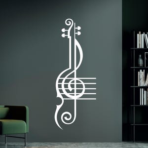 Pu&ograve; includere: Adesivo da parete in vinile bianco di una chiave di violino e note musicali su una parete grigia.