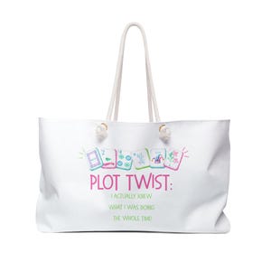 May include: White tote bag with a rope handle. The bag features the text "PLOT TWIST: I ACTUALLY KNEW WHAT I WAS DOING THE WHOLE TIME!" in pink and green. The design includes colorful illustrations of game tiles.