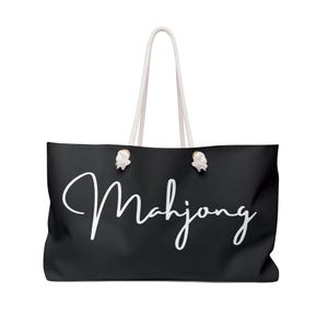 May include: Black canvas tote bag with white rope handles and the word "Mahjong" written in white cursive script.