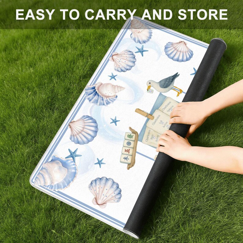 May include: A rolled-up white mat with a blue border, featuring seashell and starfish illustrations. The mat has the text "EASY TO CARRY AND STORE" at the top. The mat is being rolled up by a person.