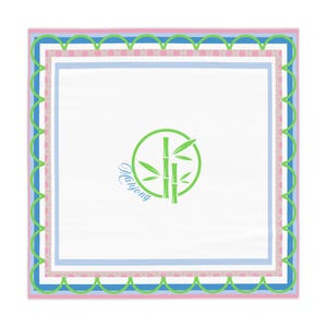 Puede incluir: Pañuelo cuadrado blanco con el tema de Mahjong con un gráfico de bambú verde dentro de un círculo. El pañuelo tiene un borde verde festoneado, con bordes rosas, azules y blancos. La palabra "Mahjong" está escrita en una fuente de guion.