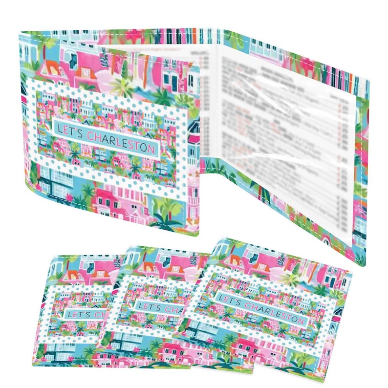 May include: A set of colorful menu holders and card holders with a Charleston theme. The holders feature a vibrant design with pink, blue, and green buildings, palm trees, and the text "LET'S CHARLESTON". The menu holders are open, revealing the inside pages.