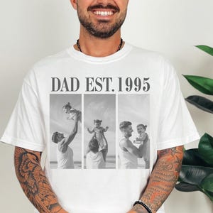 White unisex t-shirt with bold black text “DAD EST. 1995” above a black-and-white three-photo collage of a dad and daughter at the beach. Features joyful, candid fatherhood moments. Perfect personalized gift for Father’s Day, birthdays, or first-time dads. Soft, relaxed fit tee with a meaningful design—ideal for sentimental dads and custom photo apparel lovers.