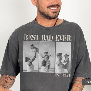 Pepper Comfort Colors t-shirt worn by a man, featuring bold “BEST DAD EVER” text with a black-and-white three-photo collage of a dad and child, and “EST. 2023” beneath. Oversized fit with candid father-child moments. Perfect personalized gift for first-time dads, Father’s Day, or baby’s first birthday. A custom photo tee celebrating fatherhood in a stylish and sentimental way.
