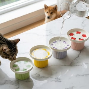 Puede incluir: Una taza de cerámica blanca con un asa negra y el texto "But First, Coffee" en negrita negra. La taza está sobre una superficie de madera. La taza mide 10 cm de alto.