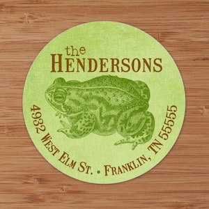 May include: A green and brown toad illustration on a light green circle with the text "the HENDERSONS 4932 WEST ELM ST. FRANKLIN, TN 55555"