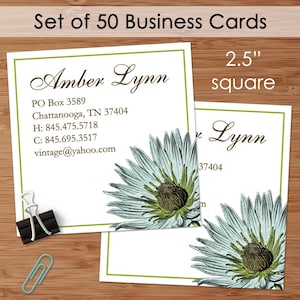 May include: Set of 50 business cards featuring a light blue flower with a brown center. The cards are 2.5 inches square and have a green border. The text on the card reads "Amber Lynn", "PO Box 3589", "Chattanooga, TN 37404", "H: 845.475.5718", "C: 845.695.3517", and "vintage@yahoo.com".