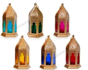 May include: Six decorative gold-colored metal lanterns with colored glass panels. Each lantern has a unique color: blue, green, pink, yellow, blue, and red. The lanterns have a decorative, openwork design and a small ring at the top.