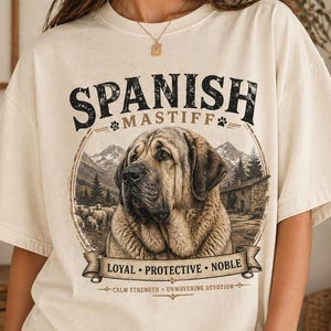 Spanish Mastiff shirt featuring a detailed vintage dog illustration printed on a premium Comfort Colors t-shirt. This oversized graphic tee showcases a loyal and protective mastiff design with rustic mountain and farm elements, perfect for dog lovers, breeders, and large dog owners. Styled in a cozy lifestyle mockup, this aesthetic dog breed shirt makes a unique gift for Spanish Mastiff fans and pet lovers.