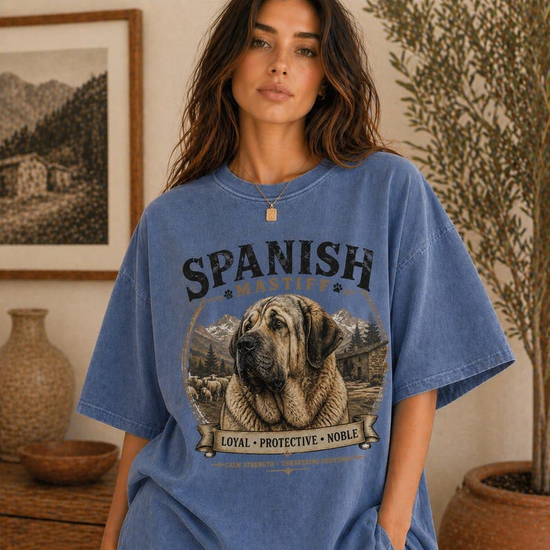 Spanish Mastiff shirt featuring a detailed vintage dog illustration printed on a premium Comfort Colors t-shirt. This oversized graphic tee showcases a loyal and protective mastiff design with rustic mountain and farm elements, perfect for dog lovers, breeders, and large dog owners. Styled in a cozy lifestyle mockup, this aesthetic dog breed shirt makes a unique gift for Spanish Mastiff fans and pet lovers.