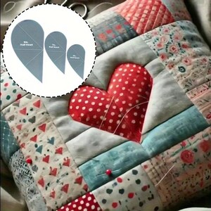 Op de afbeelding: Een patchwork kussen met een rode hart met witte stippen. Het kussen is gemaakt van stoffen vierkanten in rood, blauw en wit. Drie grijze plastic halve hart sjablonen zijn zichtbaar, met afmetingen in cm: 23, 18 en 13.