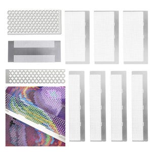 Op de afbeelding: Een verzameling zilverkleurige diamond painting tools, waaronder diverse rechthoekige en patroon sjablonen. De afbeelding toont ook een gedeeltelijk voltooide diamond painting met kleurrijke edelstenen en een witte liniaal met de tekst "MM" en "teflon".