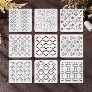 May include: Nine white square stencils with various black geometric patterns. Designs include dotted lines, floral, and woven patterns. The stencils are arranged on a brown surface, suitable for crafts and DIY projects.