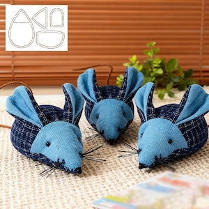 May include: Three blue fabric mouse toys with long whiskers and dark blue plaid ears. The mice are arranged on a textured surface. A pattern for the mice is visible in the upper left corner.